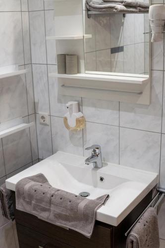 a white bathroom with a sink and a mirror at Ferienwohnung Salvenblick in Söll