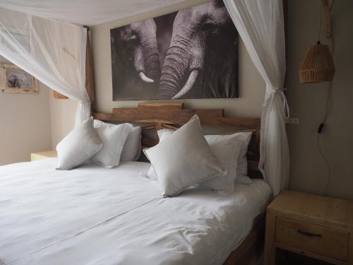 a bedroom with a bed with white sheets and pillows at Keiskama B & B in Port Elizabeth