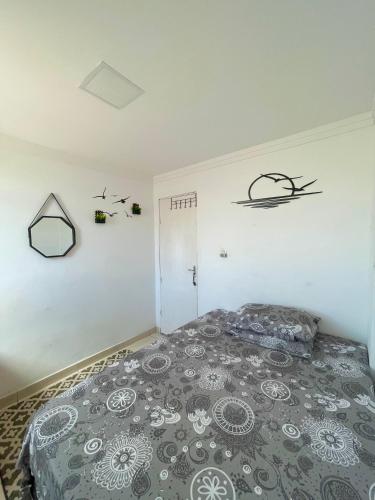 a bedroom with a bed with a gray comforter at House farol in Aracaju