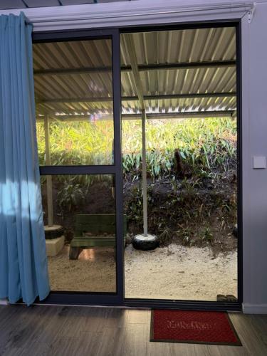 a room with a sliding glass door with a bench at Family Wolf - El Chorro in Paquera
