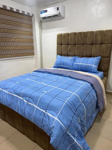 a bedroom with a bed with a blue comforter at The Pointe Apartments in Agege