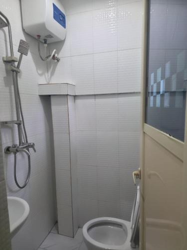 a bathroom with a toilet and a sink at The Pointe Apartments in Agege