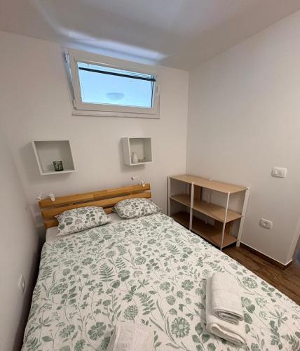 a small bedroom with a bed and a window at Apartma Zari in Marezige