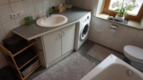 a bathroom with a sink and a washing machine at Casa di Traditionale im Herzen von Bad Aibling Tradition trifft auf moderne Gemütlichkeit auf 138qm in Bad Aibling