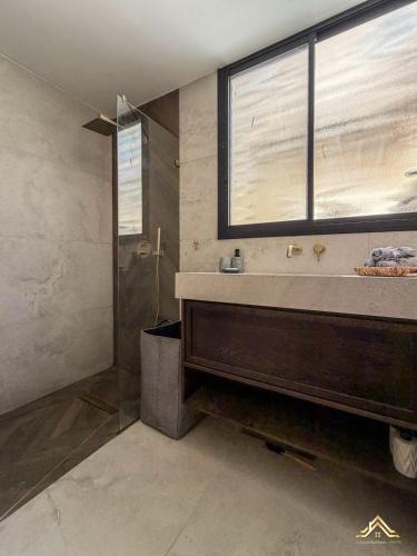 a bathroom with a sink and a glass shower at Urban Waves 1 in Netanya