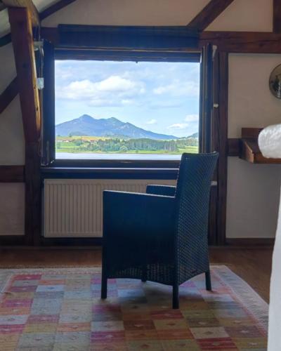 a chair sitting in front of a window with a view at Direkt am Hopfensee- große Ferienwohnung in Füssen