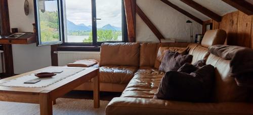 a living room with a couch and a coffee table at Direkt am Hopfensee- große Ferienwohnung in Füssen