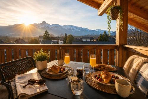 a table with bread and croissants on a balcony with the mountains at Modernes Apartment mit Alpenblick, Balkon & Parkplatz nahe Thun und Interlaken in Thun