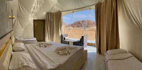 a bedroom with a bed and a large window at Tala Camp in Disah