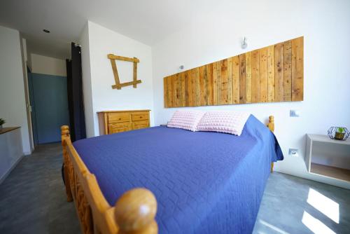 a bedroom with a blue bed with two pillows at La Belle Vue - Gîte 3 étoiles Eco Responsable Climatisé in Maury