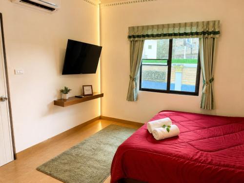 a bedroom with a red bed and a window at Affordable pool villa in premium location in Pattaya