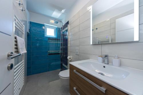 a bathroom with a sink and a toilet and a mirror at Villa Vineyard oaza in Brela