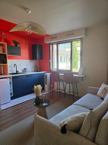 a living room with a couch and a kitchen at L'Empreinte in Cahors