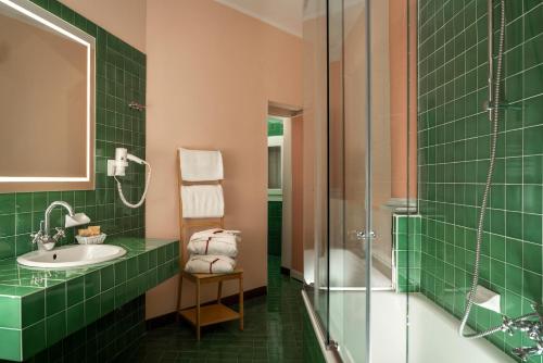 a green bathroom with a sink and a shower at Hotel Roma in Bologna