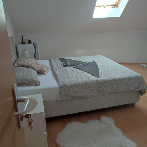 a bedroom with a bed with a rug and a window at Međimurski San in Lopatinec