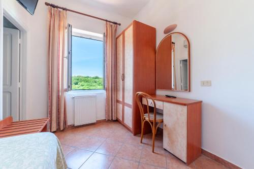 a bedroom with a desk and a mirror and a window at Hotel Monti in Casamicciola Terme