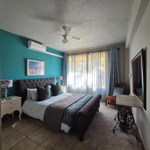 a bedroom with a large bed with a blue wall at Bekkerslaap in Potchefstroom