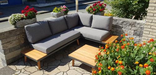 a couch and benches in a garden with flowers at Griesenstraße Morgensonne in Warendorf