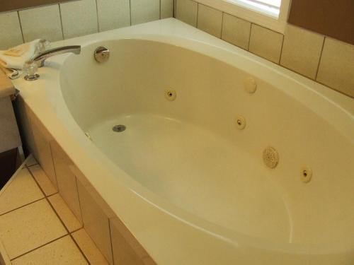 a large white bath tub in a bathroom at Ponderosa Motor Inn in Golden