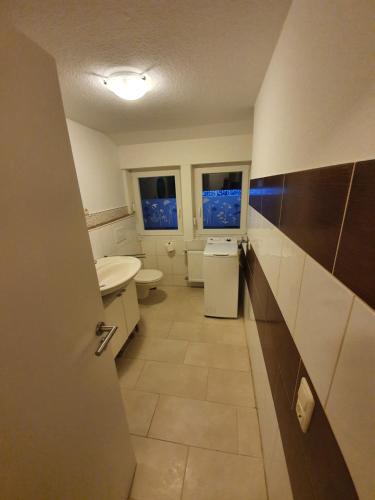 a bathroom with a sink and a toilet and windows at Griesenstraße Morgensonne in Warendorf