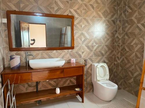 a bathroom with a sink and a toilet and a mirror at Paradise in Yène
