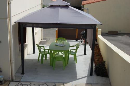 a gazebo with a table and chairs on a patio at Studio proche océan pour Deux personnes in Longeville-sur-Mer
