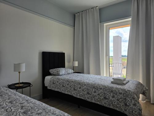 a bedroom with two beds and a window at Apartamenty Stargardt in Stargard