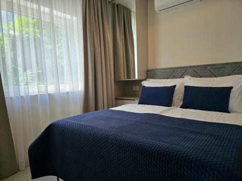 a bedroom with a blue and white bed with a window at Nautico apartment with swimming pool in Opatija