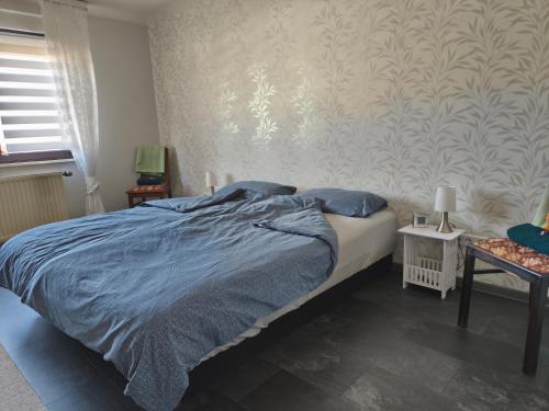 a bedroom with a bed with blue sheets and blue pillows at Ferienwohnung Marie in Nohfelden