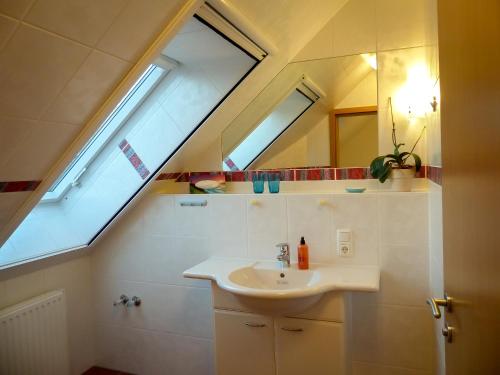 uma casa de banho com um lavatório e 2 janelas em Appartement an der Seefelder Mühle em Seefeld