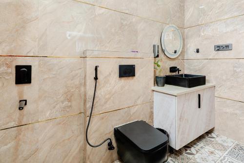 a bathroom with a toilet and a mirror at HomeGround Sector 89 -1RK in Gurgaon
