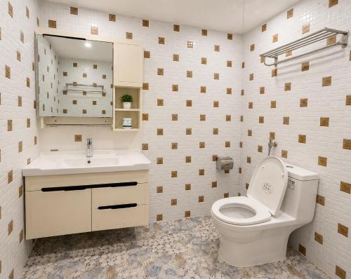 a bathroom with a toilet and a sink and a mirror at Ah Gong Boutique Bungalows in Sihanoukville