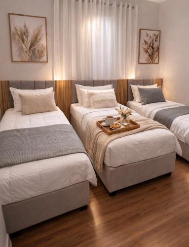 a room with three beds and a table in it at Spazio Dela vita in Sorocaba