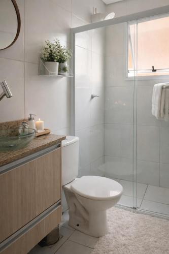 a bathroom with a toilet and a glass shower at Spazio Dela vita in Sorocaba