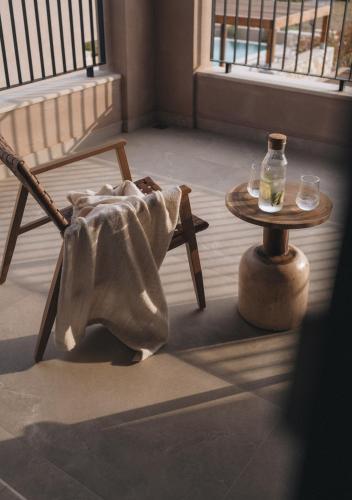 a room with a chair and a table and a bottle at Ora Blu Villas in Mytikas
