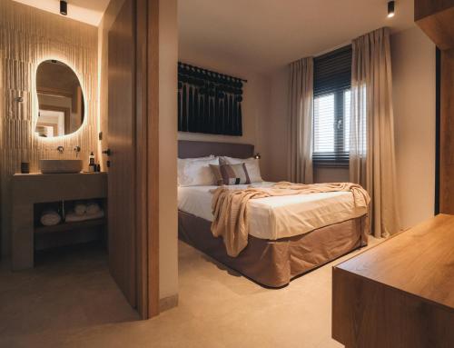 a bedroom with a bed and a mirror at Ora Blu Villas in Mytikas