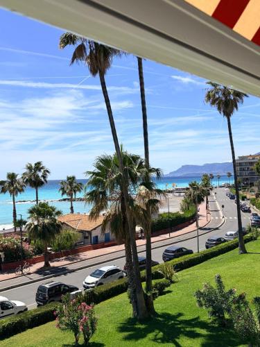 a view of a street with palm trees and the ocean at Casa Lea in Ventimiglia