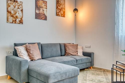 a living room with a blue couch with pillows on it at Floras House in Paradeísion