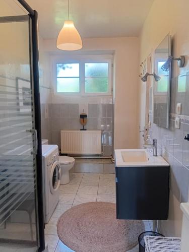 a bathroom with a sink and a washing machine at Le Tilleul du Perche - Jardin clos - Fibre - Télétravail - Parking privé in La Ventrouze