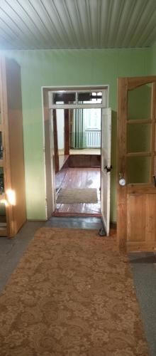 an empty room with a door and a room with green walls at Памирский дом in Khorog