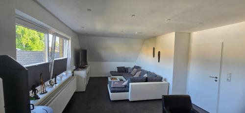 a living room with a couch and a window at Ferienwohnung in Brunsbüttel mit E-Bike Verleih in Brunsbüttel