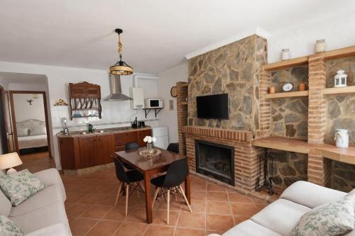 a living room with a fireplace and a table at Los Meri in Grazalema