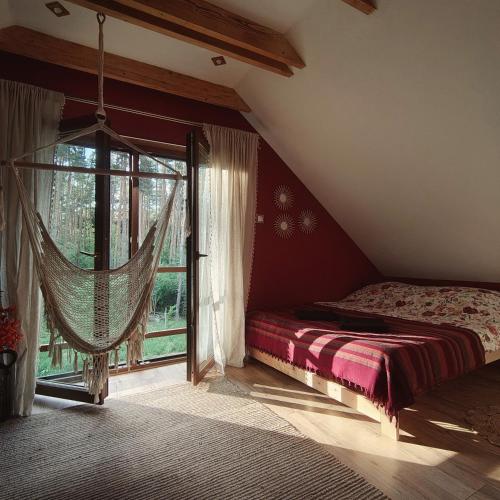 a bedroom with a bed and a large window at Domek na wynajem Lgiń in Wschowa