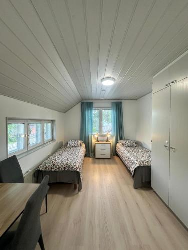 ein Zimmer mit zwei Betten und einem Tisch in einem Zimmer in der Unterkunft Airin in Imatra