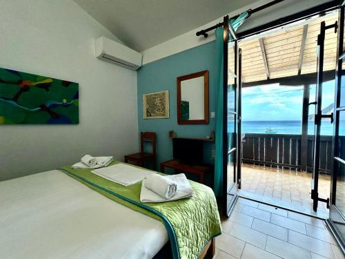 a bedroom with a bed and a view of the ocean at Fetsis Apartments in Agios Nikitas