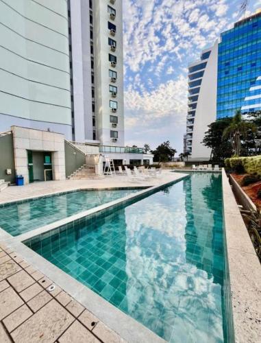 a swimming pool in front of a tall building at Apartamento completo Premium-Frente ao Mar Wi-Fi rápido-ar-condicionado in Rio de Janeiro