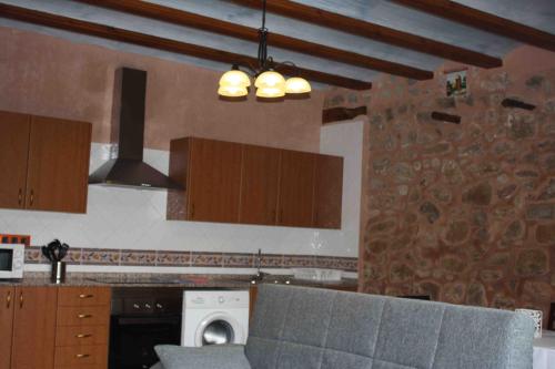 a kitchen with a stove top oven next to a microwave at Apartamentos Rio Mora in Mora de Rubielos