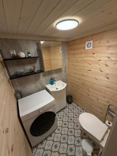 a bathroom with a white sink and a toilet at The Perfect Stop - Northern Halo in Lødingen