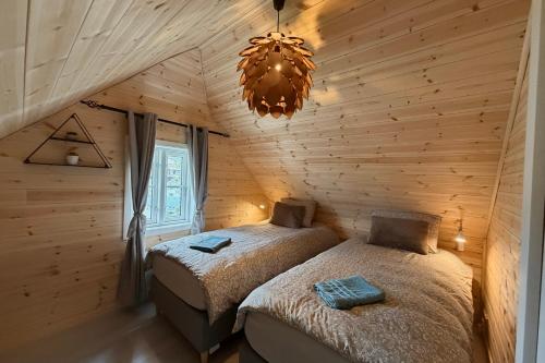 a bedroom with two beds and a chandelier at The Perfect Stop - Northern Halo in Lødingen