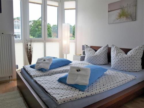 a bedroom with two beds with blue and white pillows at Strandstraße by Rujana in Baabe